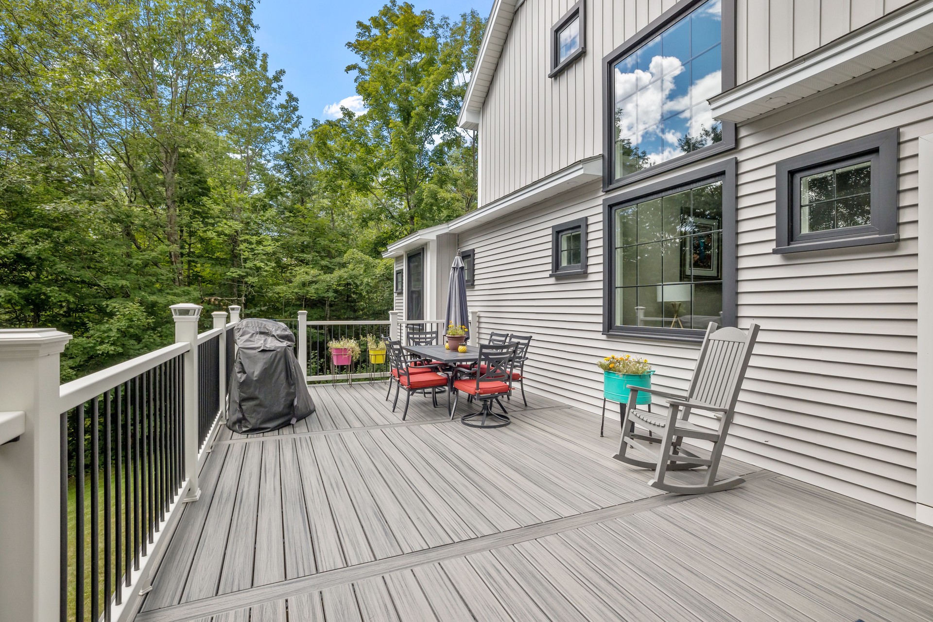 Modern custom new England colonial home with an American flag on a sunny day